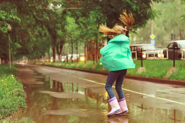 Девушка играет под весенним дождем — стоковое фото