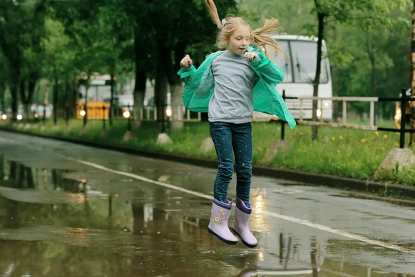 Lány játszik a tavaszi eső — Stock Fotó