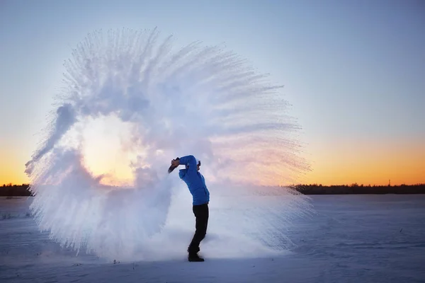 男人把雪扔在日落 — 图库照片