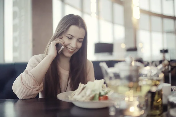 Młoda kobieta przy użyciu telefonu w kawiarni — Zdjęcie stockowe