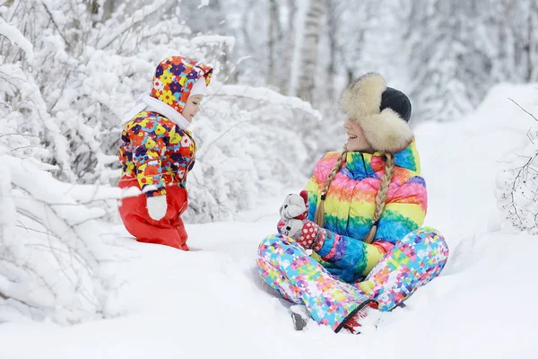 Chica con madre en el parque cubierto de nieve —  Fotos de Stock