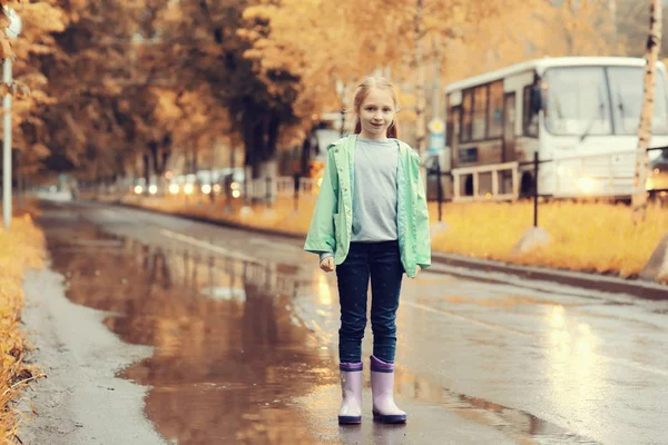 Flicka som leker utomhus efter regn — Stockfoto