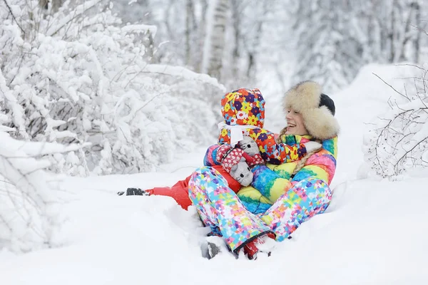 Женщина и ребенок, играющие зимой — стоковое фото