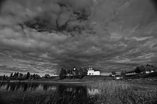 Церковь на берегу реки осенью — стоковое фото