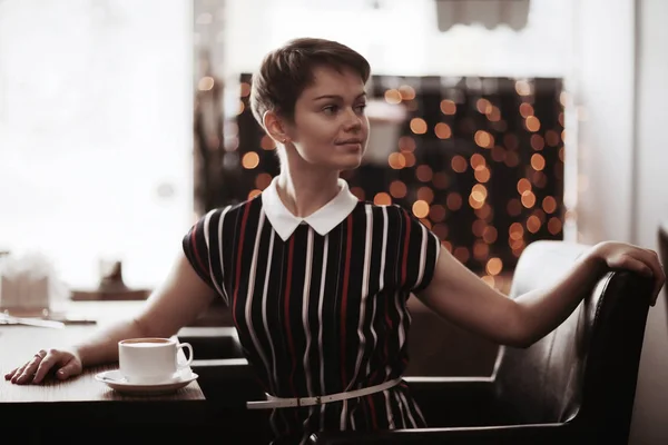 Коротковолосая девушка, сидящая в кафе — стоковое фото