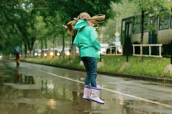春の雨の下で遊ぶ女の子 — ストック写真
