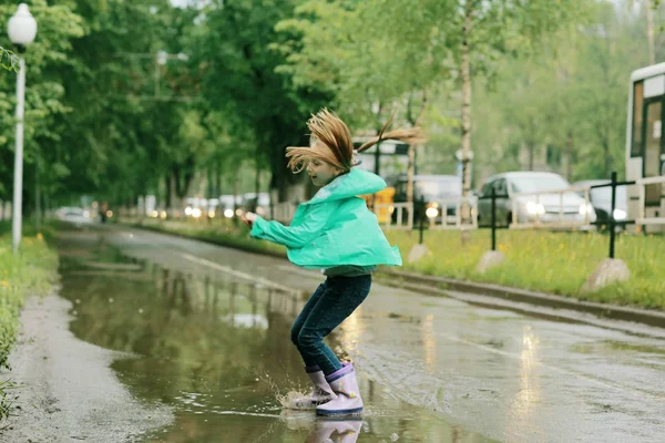 Flicka som leker under våren regn — Stockfoto