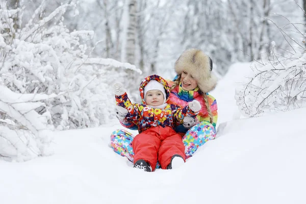 Женщина и ребенок, играющие зимой — стоковое фото