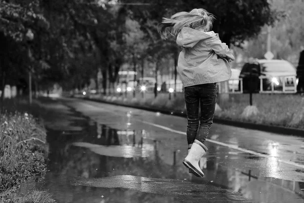 Chica jugando al aire libre después de la lluvia —  Fotos de Stock