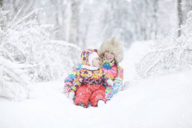  kadın ve kışın oynayan bir çocuk 