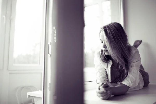 Giovane donna sdraiata su una finestra — Foto Stock