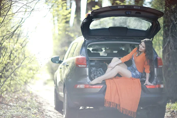 Mulher sentada na bagageira do carro — Fotografia de Stock