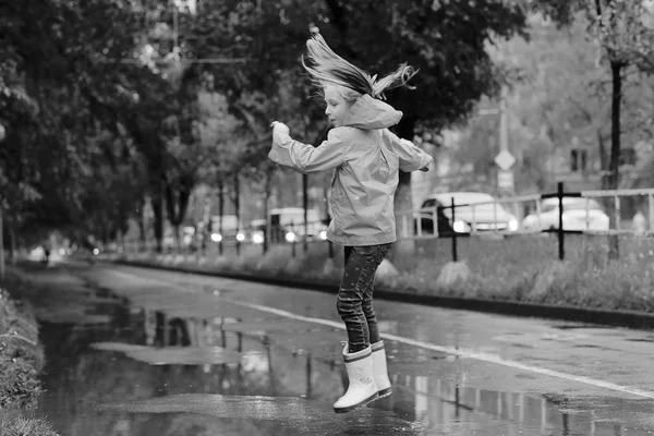 春の雨の下で遊ぶ女の子 — ストック写真