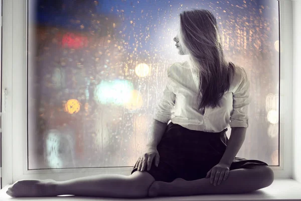 창턱에 앉아 슬픈 소녀 — 스톡 사진