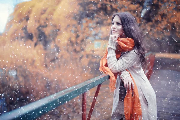 Jeune fille avec des flocons de neige dans l'air — Photo