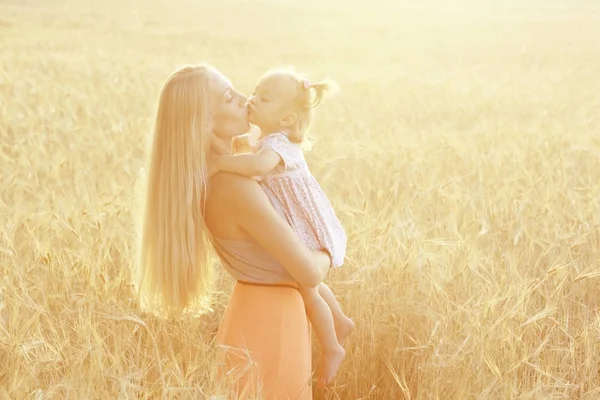 Mamma kramar dotter i fältet — Stockfoto