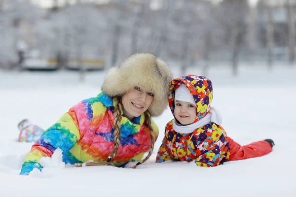 Ребенок и мать веселятся зимой — стоковое фото