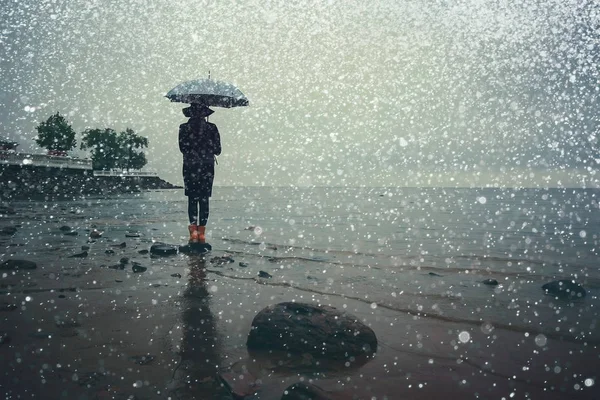 Vrouw met een paraplu aan zee — Stockfoto