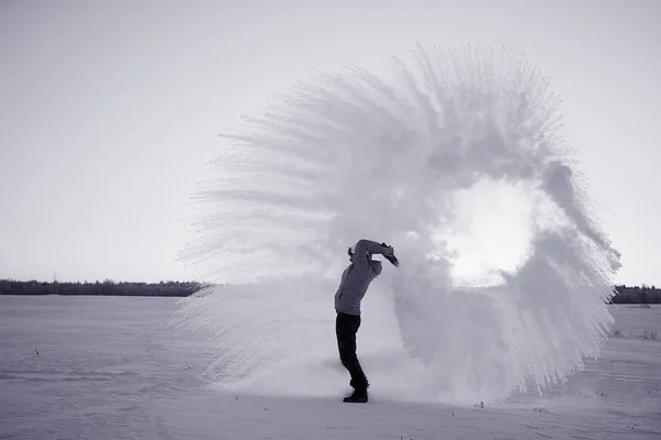 Uomo che lancia neve al tramonto — Foto Stock