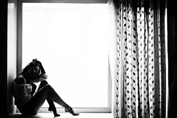 Νεαρή γυναίκα ξαπλωμένη σε ένα παράθυρο — Φωτογραφία Αρχείου