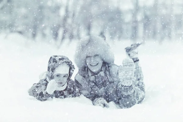 Hija y madre jugando en la nieve — Foto de Stock
