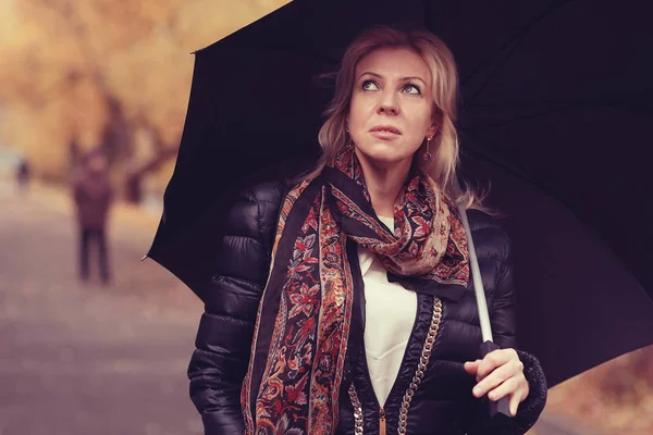Женщина с зонтиком в осеннем парке — стоковое фото