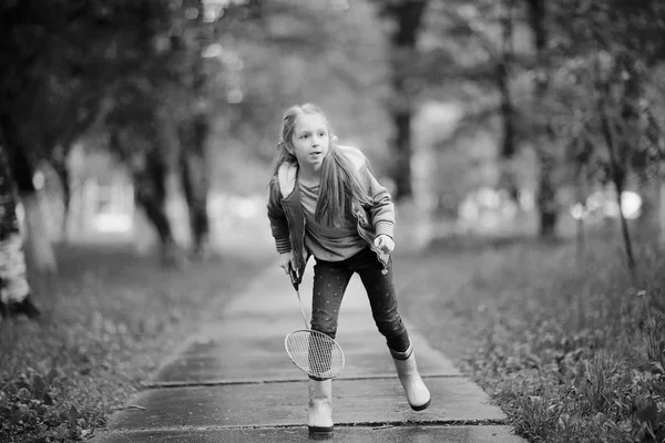 Девушка играет в бадминтон в парке — стоковое фото