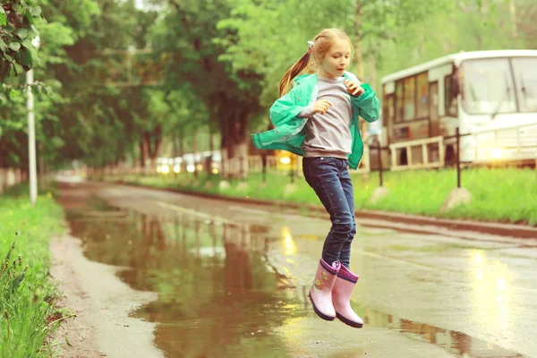 Flicka som leker under våren regn — Stockfoto