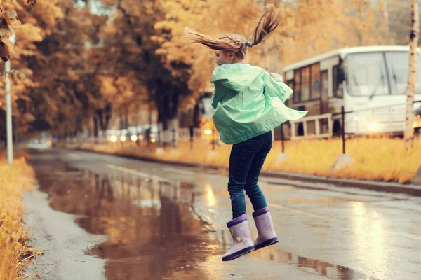 Девушка играет на открытом воздухе после дождя — стоковое фото