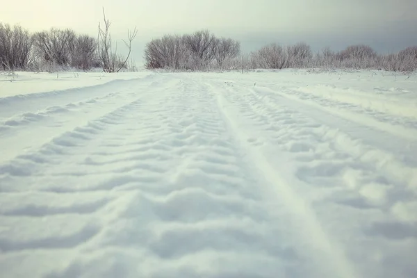 Faixas na estrada de inverno nevado — Fotografia de Stock