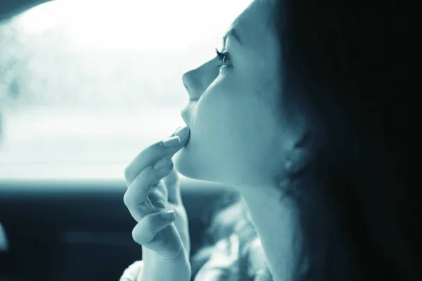 Girl painting lips in the car — Stock Photo, Image