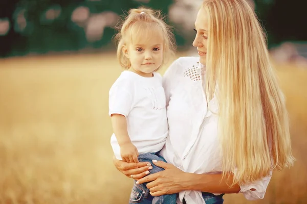 Mamma kramar dotter i fältet — Stockfoto