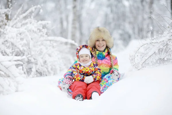 Mulher e uma criança brincando no inverno — Fotografia de Stock