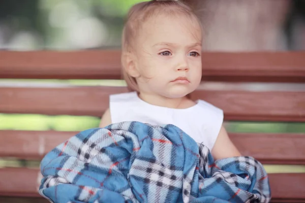 在公园长椅上坐着的小女孩 — 图库照片
