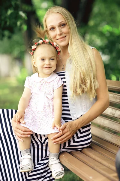 Mamá con una niña en el banco — Foto de Stock