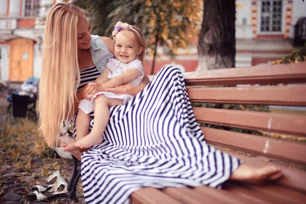 Mamá con una niña en el banco —  Fotos de Stock