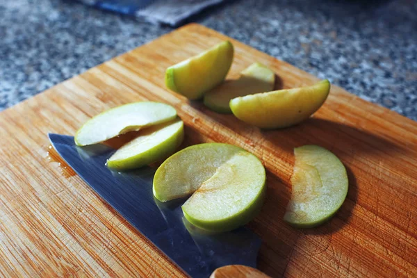 Нарезанное зеленое яблоко на столе — стоковое фото