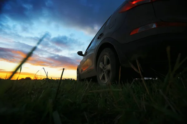 Автомобіль в полі на заході сонця — стокове фото