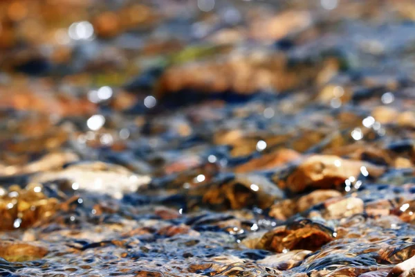 Multi-colored pebbles in a stream — Stock Photo, Image