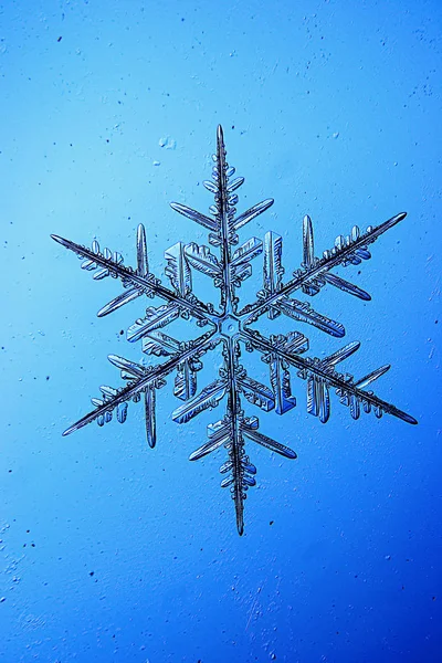 Schneeflocke auf blauem Hintergrund — Stockfoto