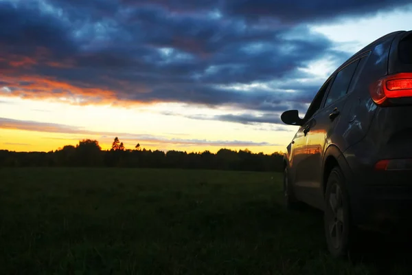 Автомобіль в полі на заході сонця — стокове фото