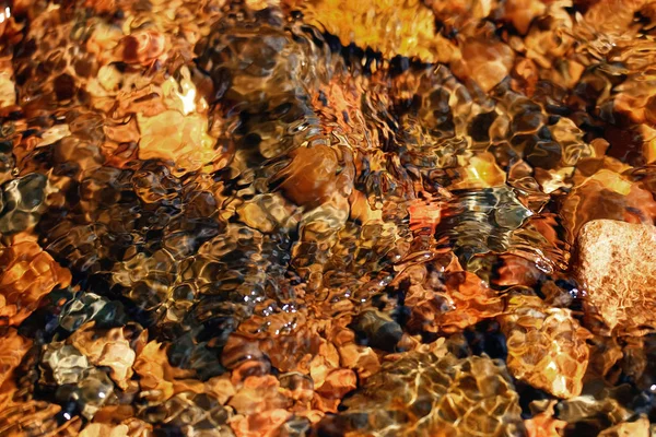 Multi-gekleurde steentjes in een stroom — Stockfoto