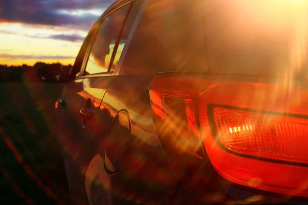 Auto in het veld bij zonsondergang — Stockfoto