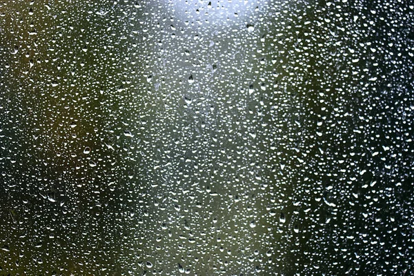 Gotas de chuva que fluem pelo vidro — Fotografia de Stock