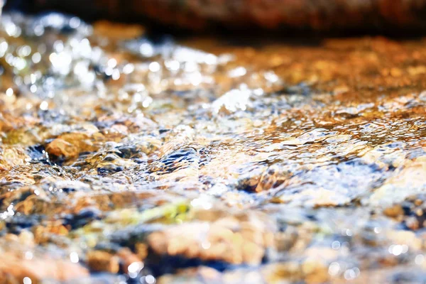 Multi-colored pebbles in a stream — Stock Photo, Image