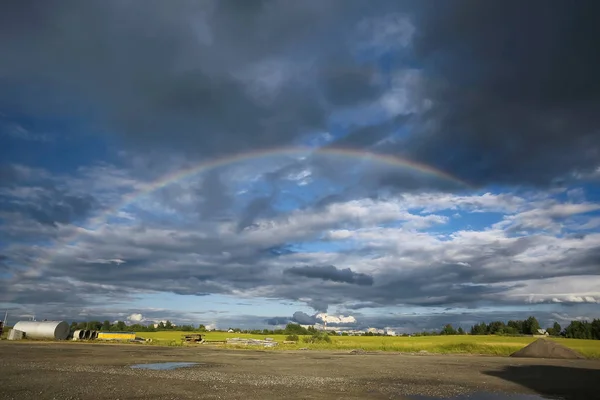Rainbow in a field by the road — Stock Photo, Image