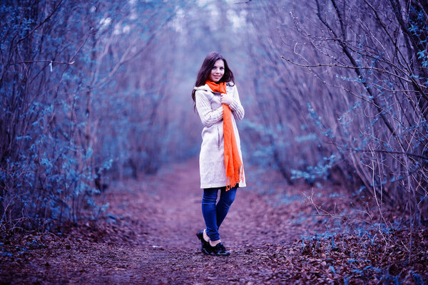 Young beautiful woman with orange scarf relaxing in autumn forest