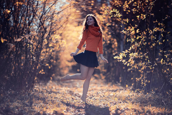 Young happy woman relaxing in picturesque autumn park