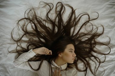 yatakta uzun saçlı genç kız