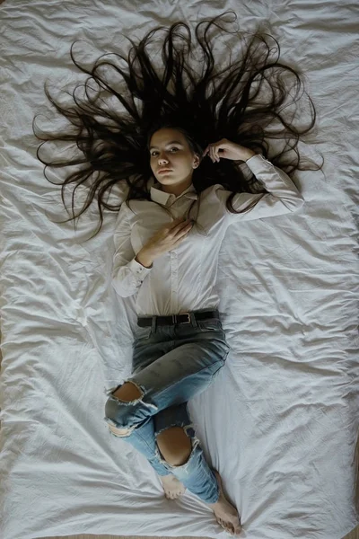 Дівчина-підліток з довгим волоссям у ліжку — стокове фото